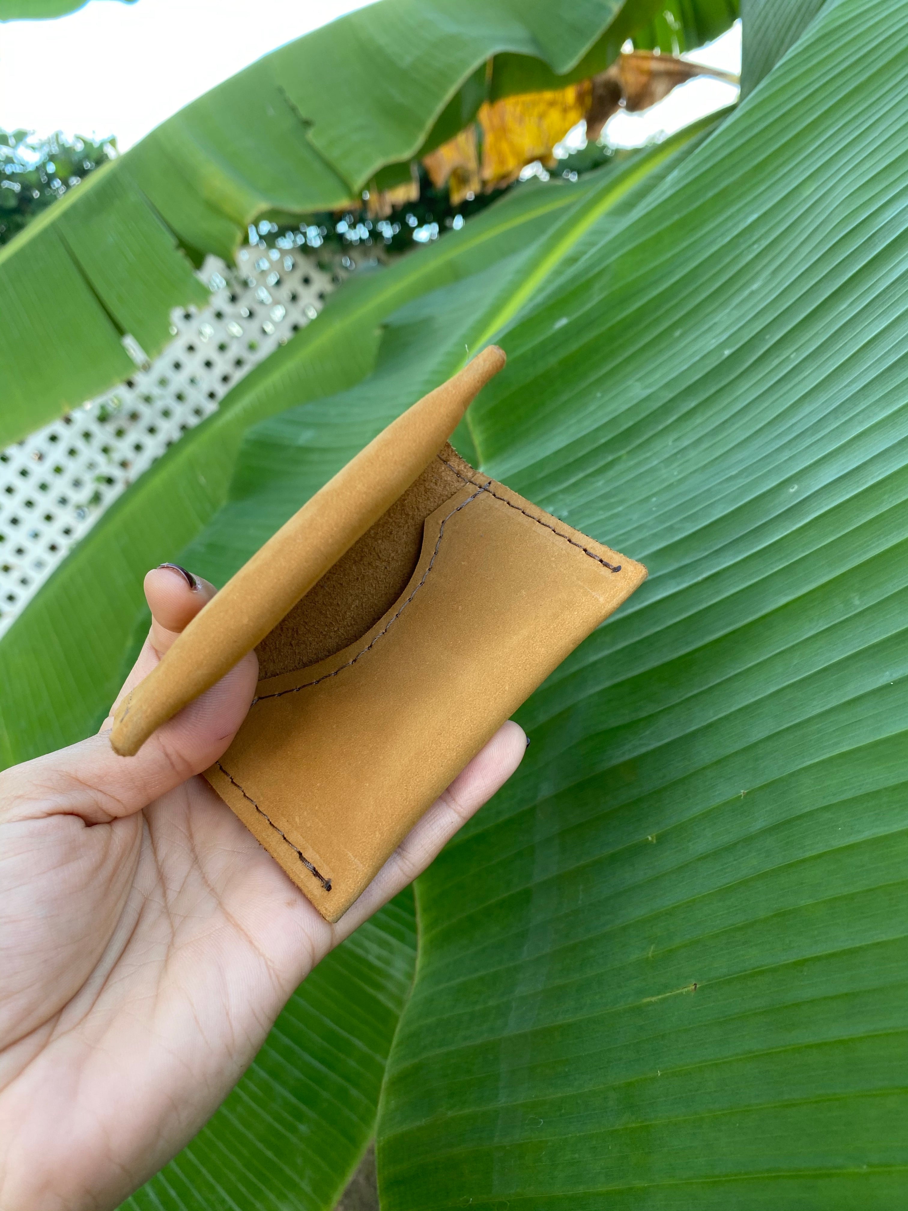 Tan small bifold handcrafted wallet. Each side holds 10 cards. We love putting folded bills on one side and cards on the other.