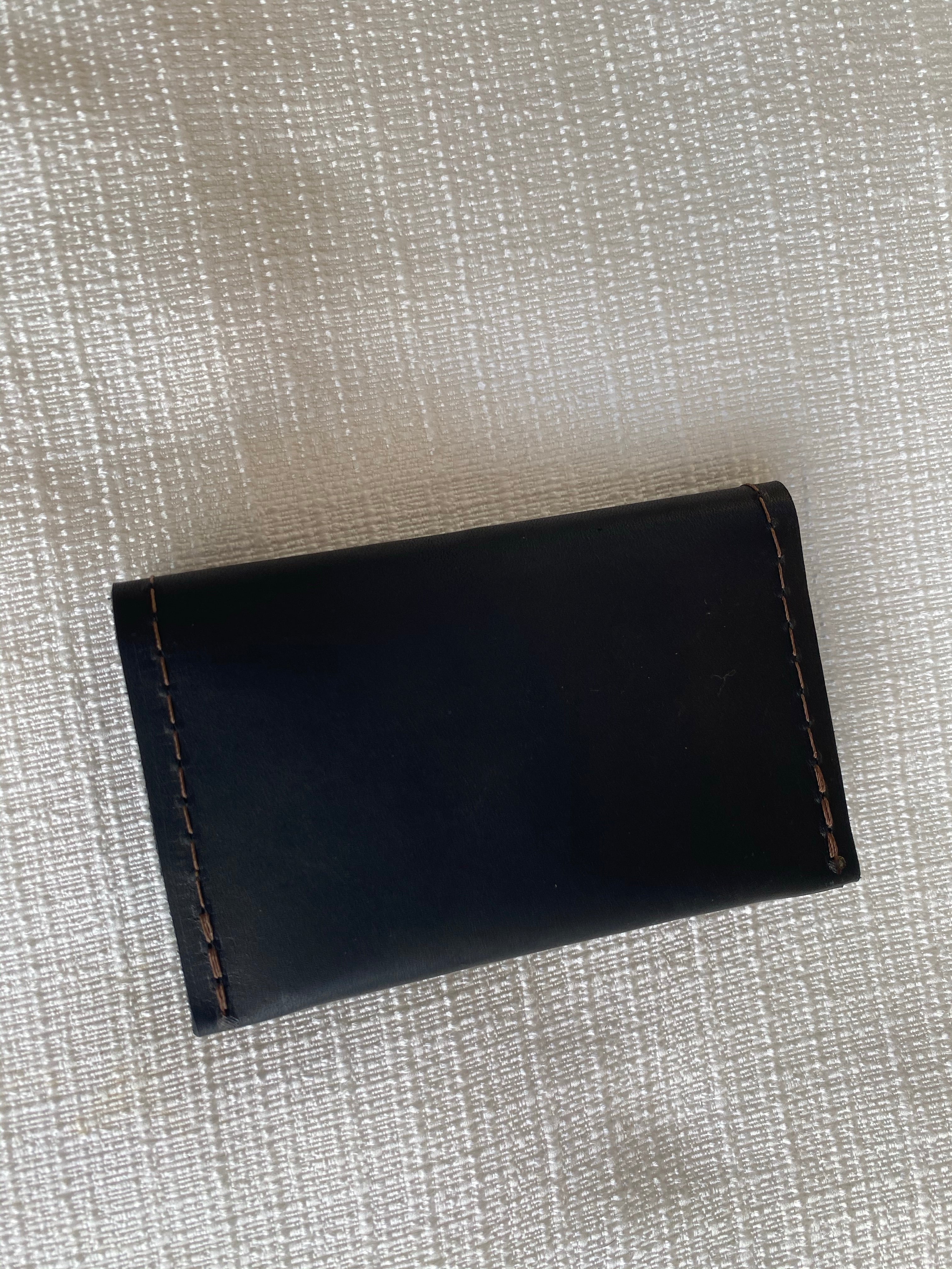 Black small bifold handcrafted wallet. Each side holds 10 cards. We love putting folded bills on one side and cards on the other.