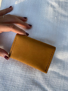 Tan small bifold handcrafted wallet. Each side holds 10 cards. We love putting folded bills on one side and cards on the other.
